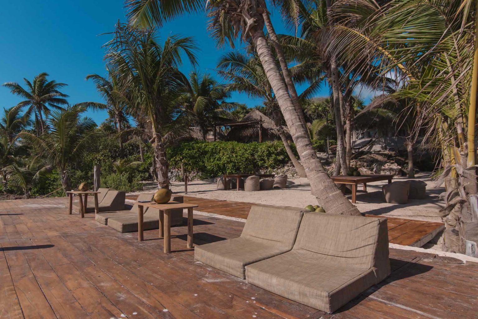 Lounge chairs on a deck at the beach club | Papaya Playa Project