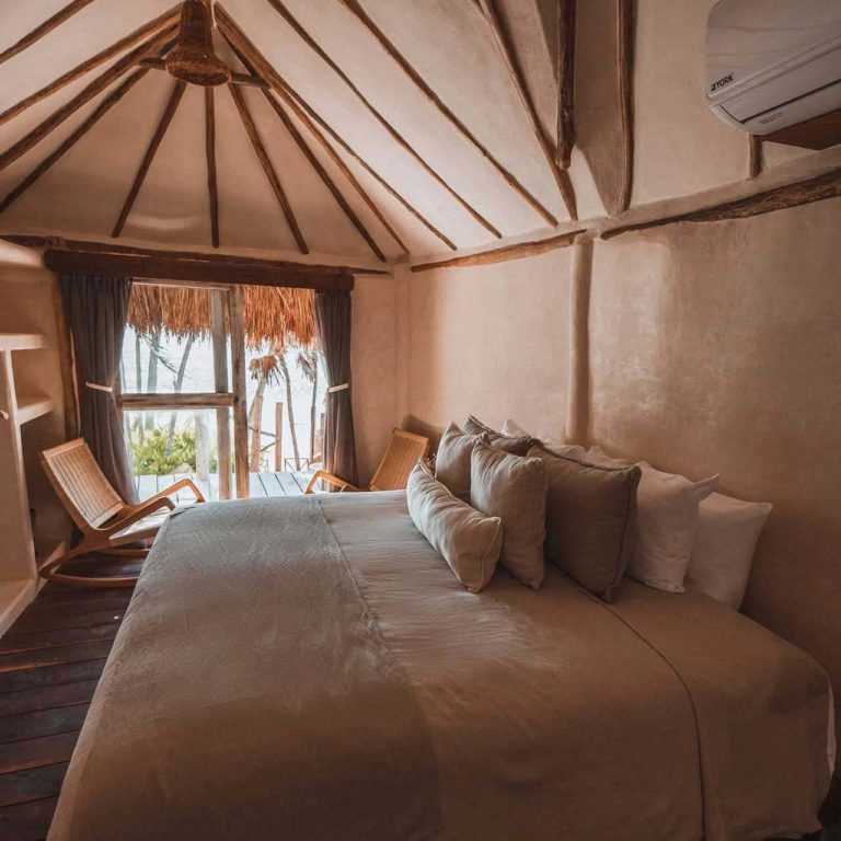 Casa Coco - dormitorio con cama king y sala de estar en el Proyecto Papaya Playa