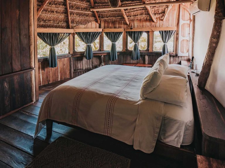 Casa Viento - dormitorio con cama king y muchas ventanas en el Proyecto Papaya Playa