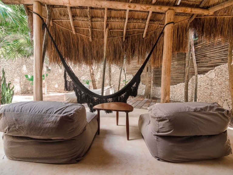 Casita jungle view with pool - covered patio with lounge chairs and hammock at the Papaya Playa Project