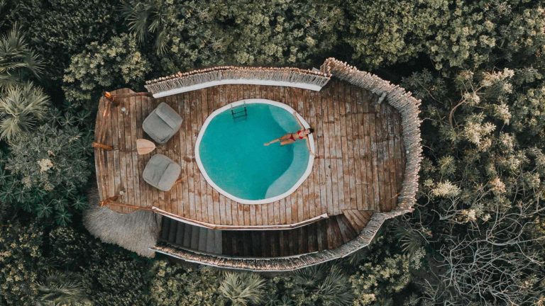Mujer relajándose en la piscina de la azotea de su Casita con vista a la jungla en el Proyecto Papaya Playa