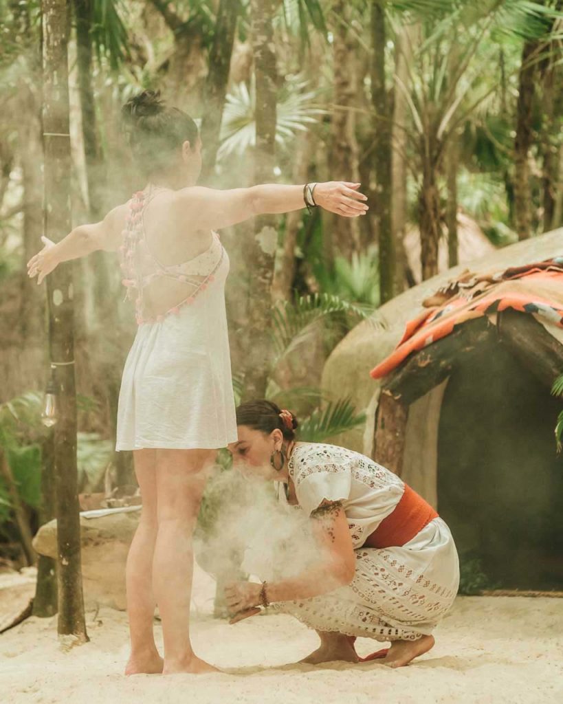 Woman getting a steam by the Temazcal at the Papaya Playa Project