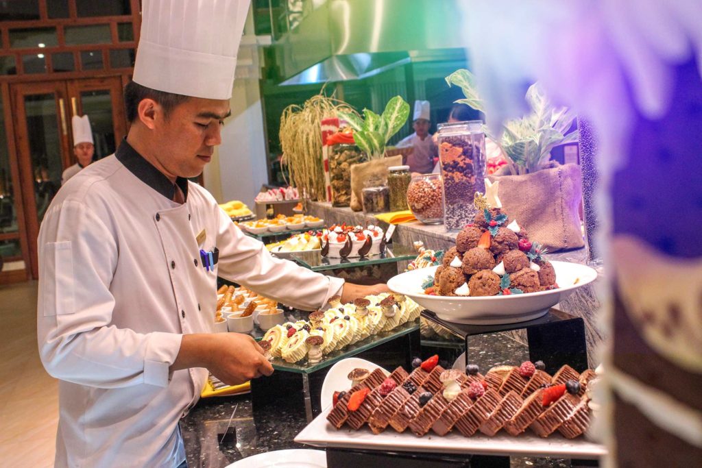Koch legt Tabletts am Buffet des Restaurants Kurkuma des Sokha Siem Reap Resorts aus
