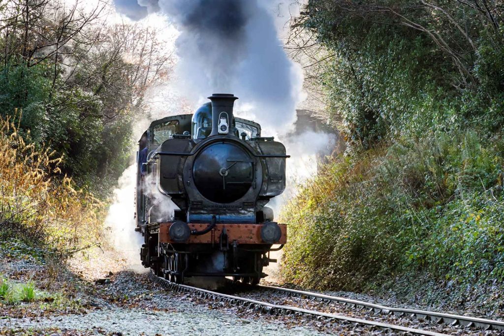 Locomotora de vapor que viaja sobre las vías del tren