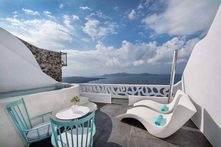 Suite Cave - Balcón al aire libre con mesa de comedor, sillones, jacuzzi y vista al mar | Suites de lujo Athina