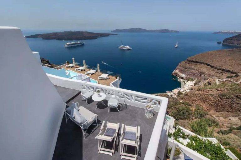 Suite Deluxe - Balcón al aire libre con mesa de comedor y sillones con vista al mar | Suites de lujo Athina