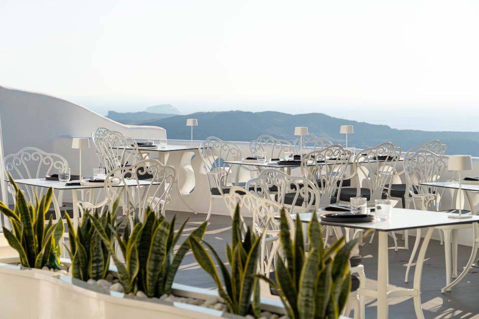 Mesas y sillas de balcón al aire libre en el restaurante Esperisma | Suites de lujo Athina