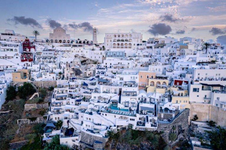 Front view of Athina Luxury Suites and surrounding buildings set into the cliffs of Santorini Island