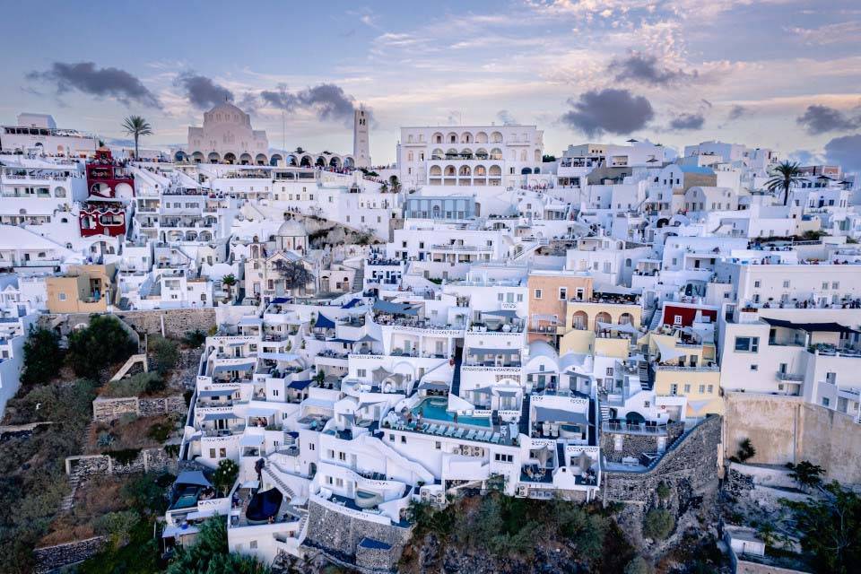 Vista frontal de Athina Luxury Suites y los edificios circundantes ubicados en los acantilados de la isla de Santorini