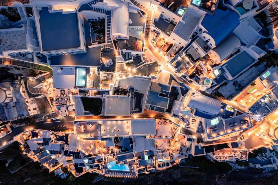 Vista aérea de Athina Luxury Suites y los edificios circundantes iluminados por la noche