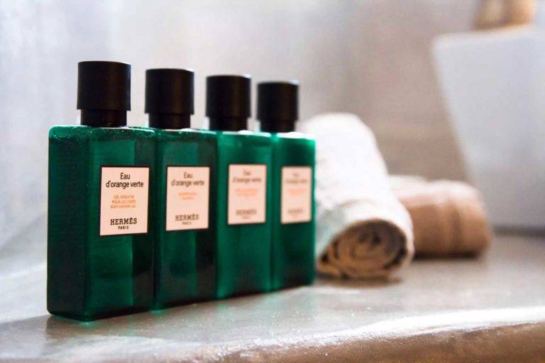 Artículos de baño tamaño viaje en botellas verdes en Athina Luxury Suites
