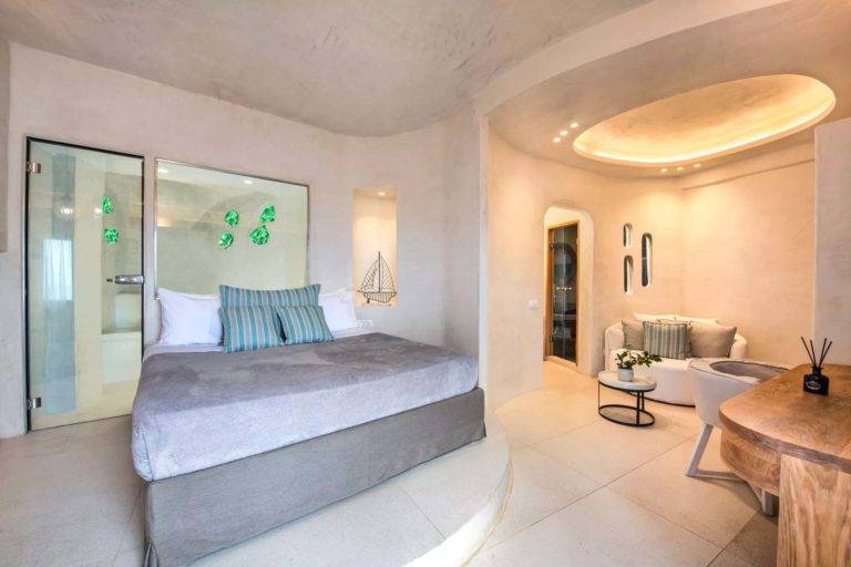 Suite Luna de Miel - Dormitorio con cama, estación de trabajo y sala de estar | Suites de lujo Athina