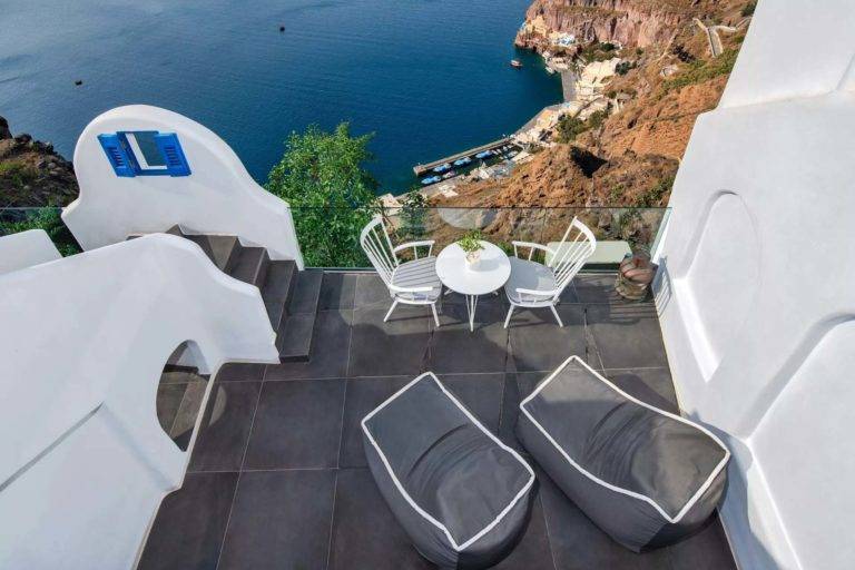Junior Cave Suite - Balcón al aire libre con mesa de comedor y sillones con vista al mar | Suites de lujo Athina