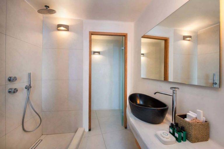 Junior Suite - Baño con ducha de lluvia con función de ducha de mano, tocador individual, espejo y artículos de tocador | Suites de lujo Athina