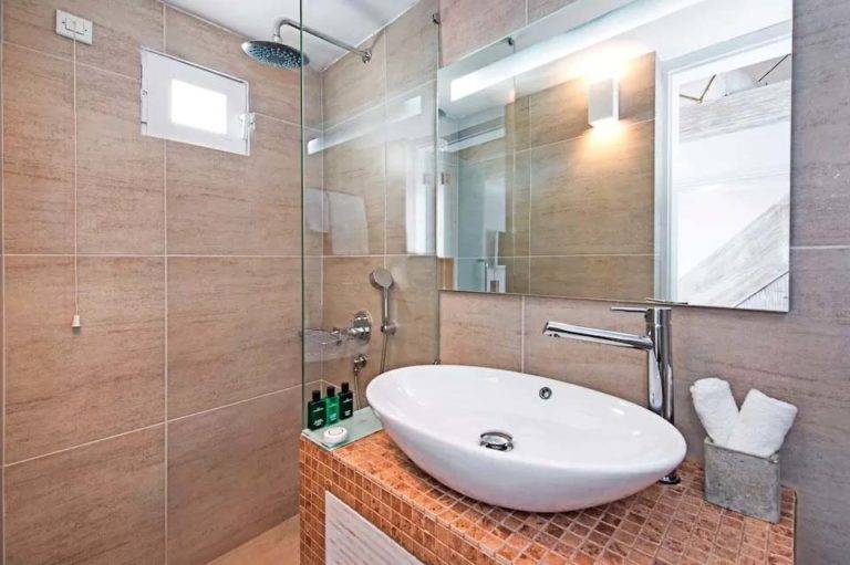 Master Loft Suite - Baño con ducha de lluvia, ducha de mano, tocador, espejo y artículos de tocador | Suites de lujo Athina