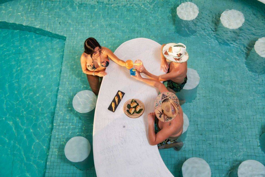 Gente disfrutando de cócteles y bocadillos en el bar de la piscina en Athina Luxury Suites