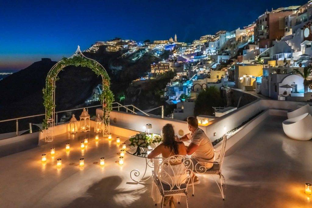 Una pareja disfruta de una cena privada a la luz de las velas en un balcón de Athina Luxury Suites