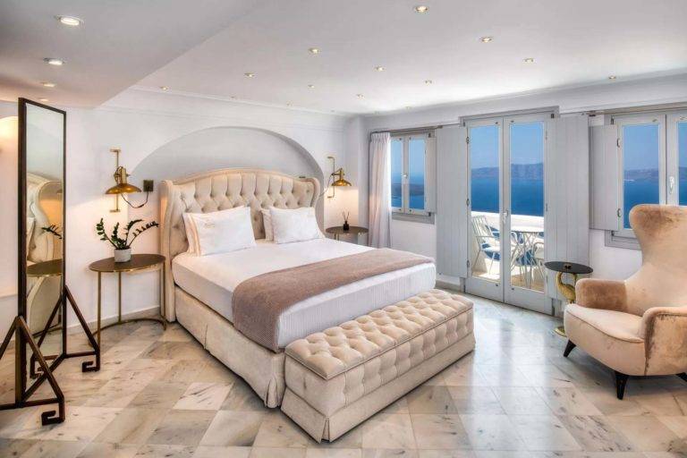 Royal Suite: dormitorio principal con cama King, sala de estar y puertas francesas que dan al balcón | Suites de lujo Athina
