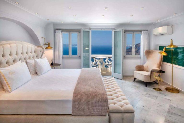 Royal Suite: dormitorio principal con cama King, sala de estar y puertas francesas que dan al balcón | Suites de lujo Athina