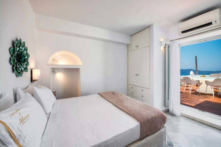 Royal Suite: dormitorio con cama King, armario empotrado y puertas francesas que dan al balcón | Suites de lujo Athina