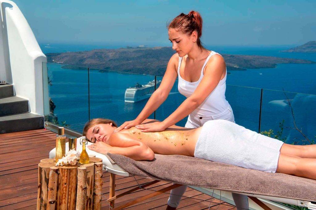 Mujer recibiendo un masaje en un balcón en Athina Luxury Suites