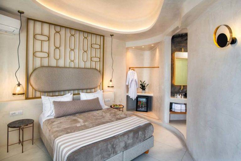 Suite Superior - Recámara con cama king, clóset abierto, mini refrigerador y baño en suite | Suites de lujo Athina