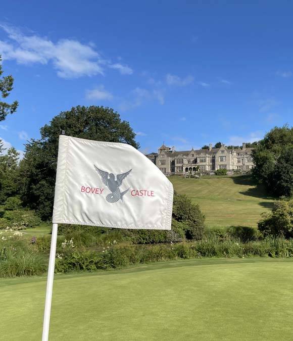 Bovey castle golf hole flag with Bovey Castle in the background