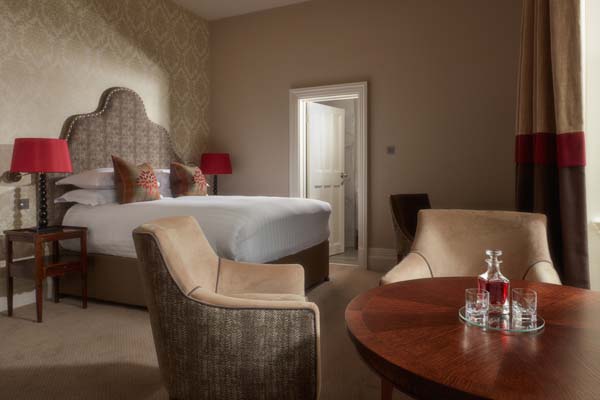 Castle Room - Bedroom with king bed and sitting area with a table | Bovey Castle