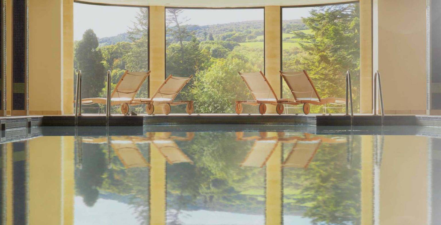 Indoor pool with lounge chairs at the Bovey Castle Spa