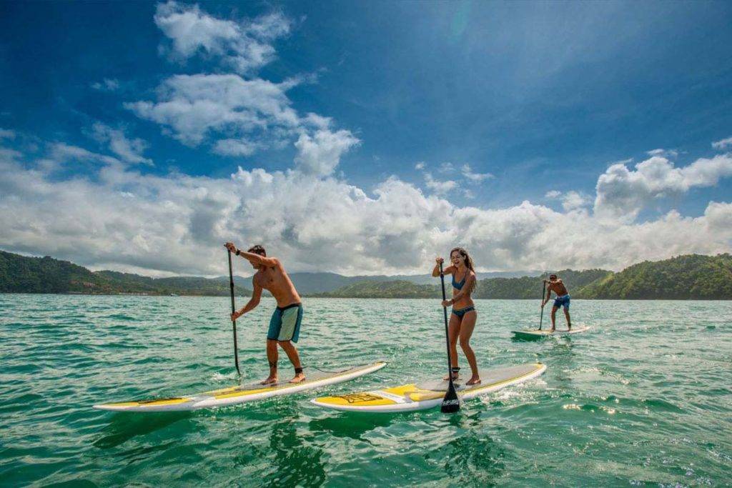 Grupo de personas surf de remo en el océano | Los Sueños Resort & Marina