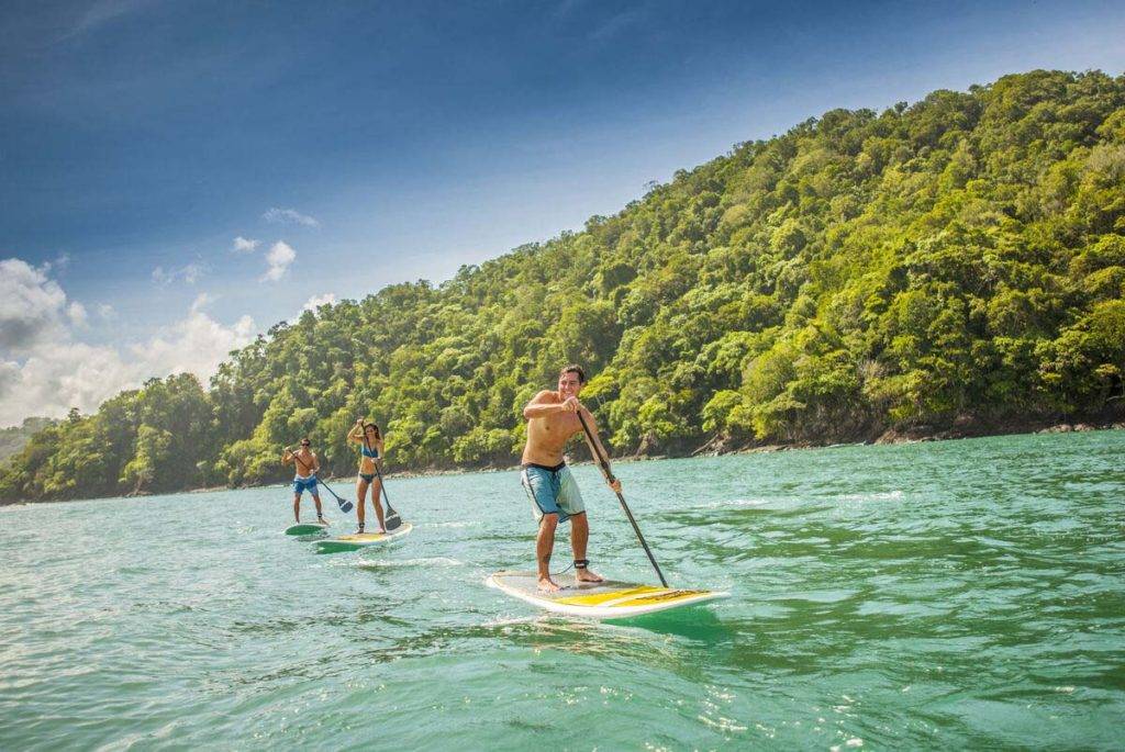 Grupo de personas surf de remo en el océano | Los Sueños Resort & Marina