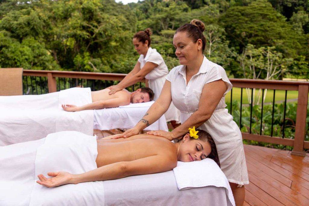 Pareja recibiendo masajes en la espalda en una terraza al aire libre | Los Sueños Resort & Marina