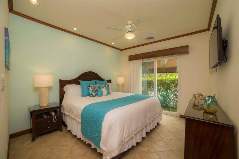 Una habitación de lujo: cama King con mesita de noche, tocador y TV montada | Residencias Veranda, Los Sueños Resort & Marina