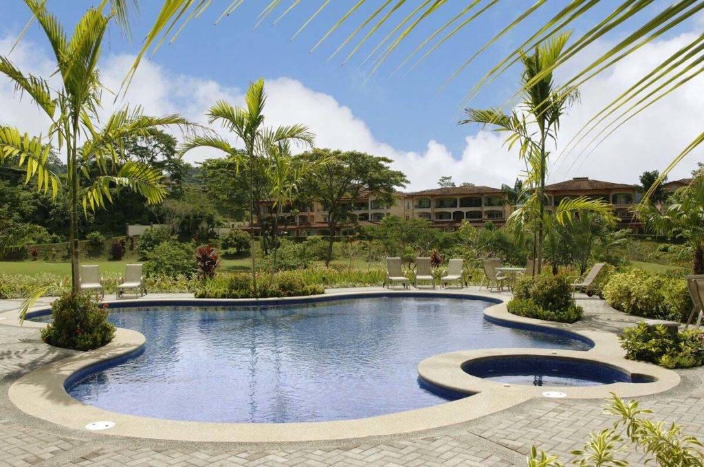 Veranda Piscina residencial rodeada de patio con camastros y palmeras | Los Sueños Resort & Marina