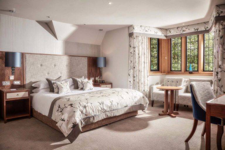 Accessible Superior Deluxe Room - King bedroom with seating area, workstation, and a bay window | Mallory Court