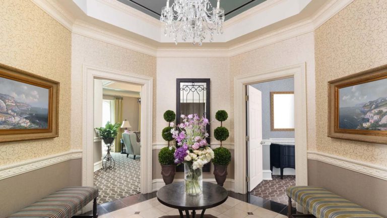 Chateau Presidential Suite - Foyer d'inspiration européenne avec bancs et fleurs fraîches | Némacolin