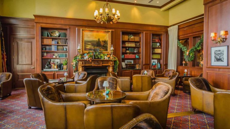 The Cigar Bar - Room with bookshelves and traditional tables and chairs | Nemacolin