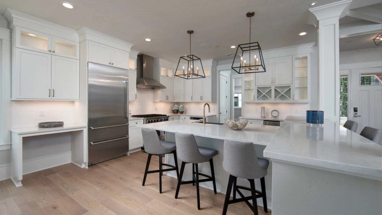 The Estates Mallard's Landing - Modern white kitchen with stainless steel appliances and bar seating | Nemacolin
