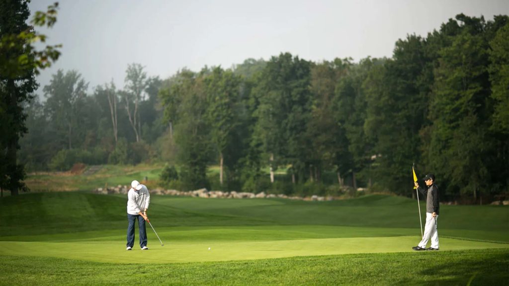 Men playing a round of golf on the Mystic Rock Golf Course | Nemacolin