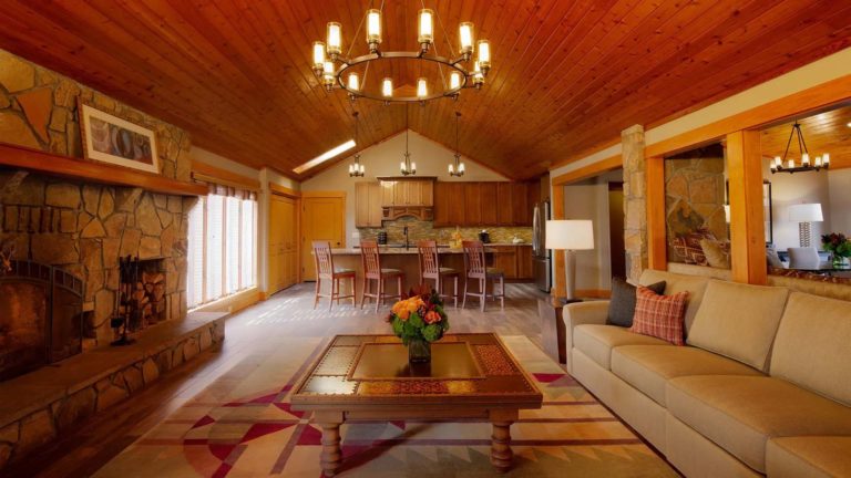 The Homes Deer Path Lodge - Rustic family room with fireplace, open to the kitchen | Nemacolin