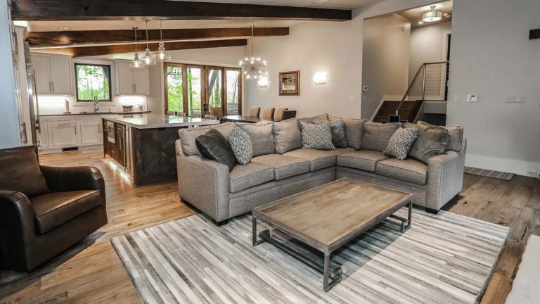 The Homes Greystone: sala de estar de concepto abierto con sofá seccional y mesa de centro | nemacolina