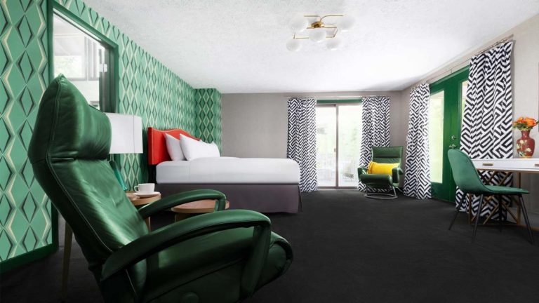 The Homes Grouse Glen: dormitorio con cama King, sala de estar y estación de trabajo con detalles decorativos en verde | nemacolina