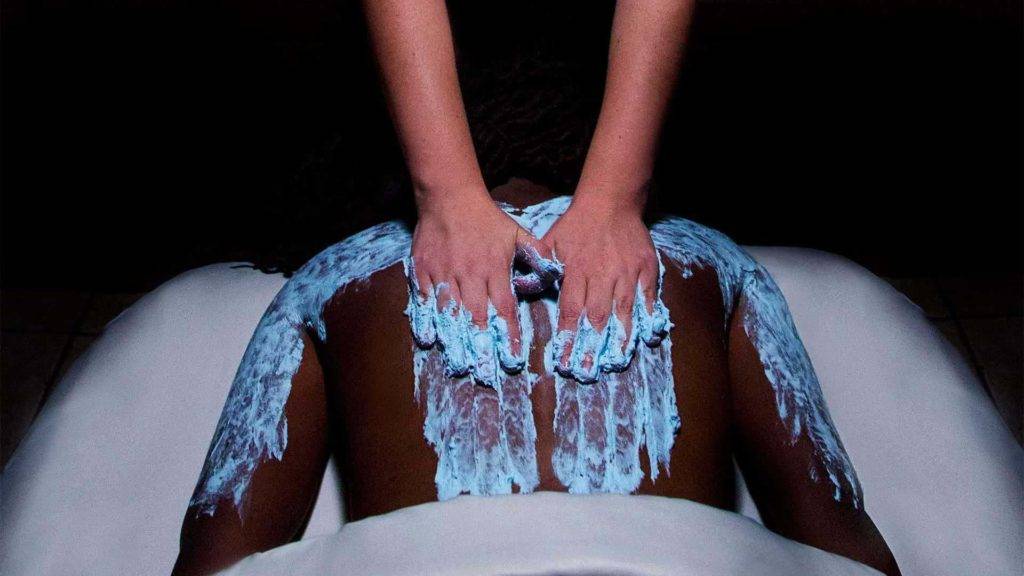 Hombre recibiendo un masaje de espalda con loción azul en el spa Nemacolin