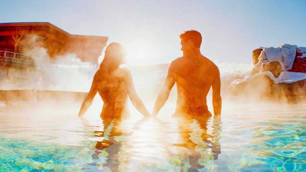 Couple standing in a heated pool at the Peak | Nemacolin
