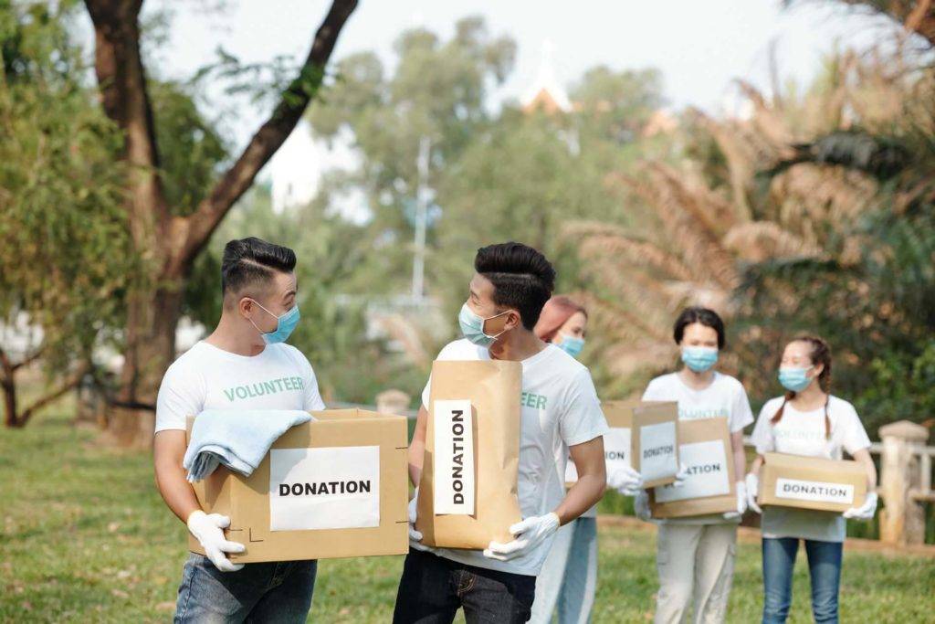 Groupe de bénévoles transportant des cartons lors d'un événement caritatif