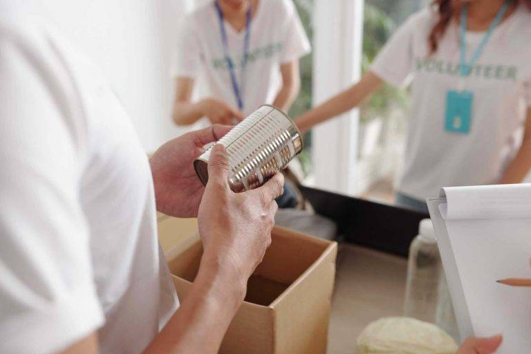 Freiwillige packen Konserven in Kisten