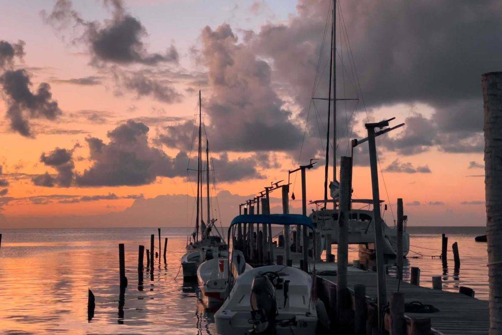 Boats parked on a dock at sunset in Placencia, Belize