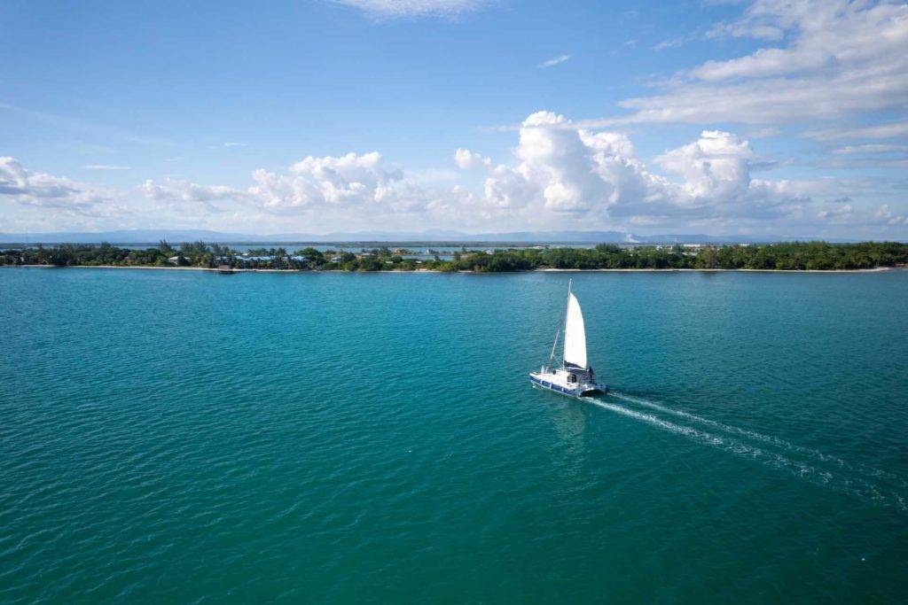 A sailboat riding on calm ocean waters on a beautiful day in Belize