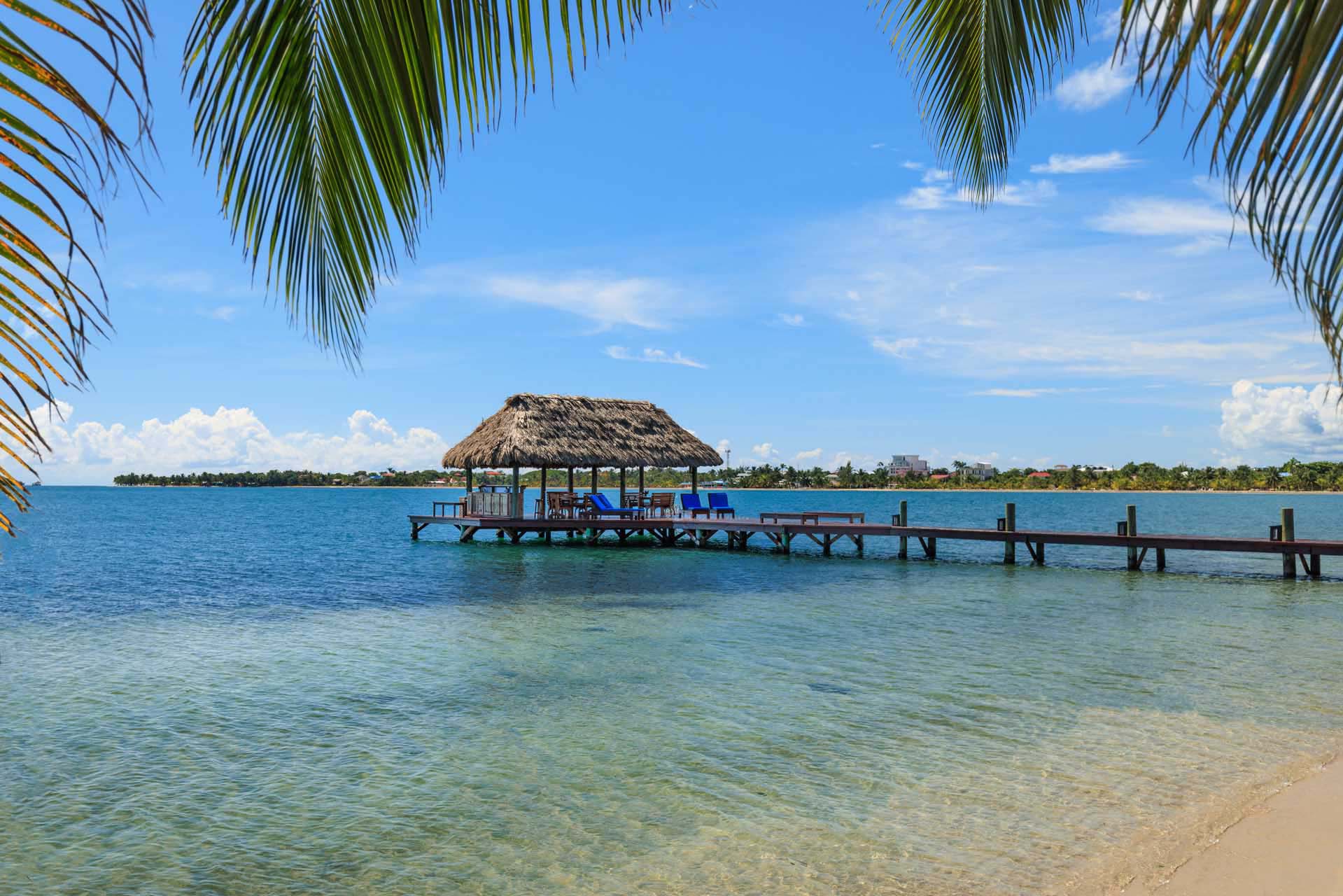 Covered dock with thatched roof set over the ocean at Chabil Mar Villas