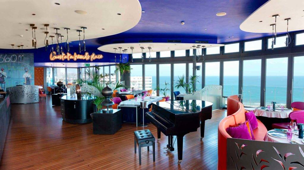 360 Mesas y sillas de restaurante con piano y grandes ventanales con vistas panorámicas al mar | Bohemia Suites & Spa